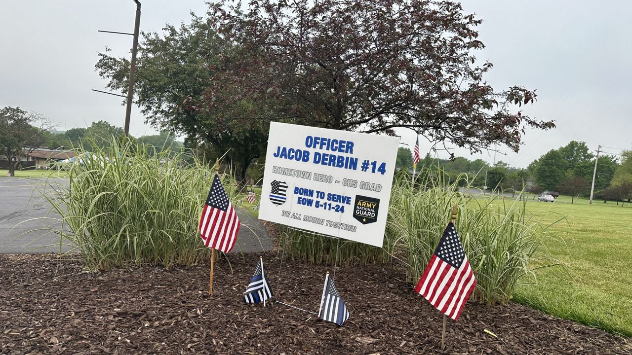 A sign and flags sit outside St. Columbkille Church on Broadview Road in Parma Saturday morning, where the funeral for Jacob Derbin is to take place at 11 a.m.