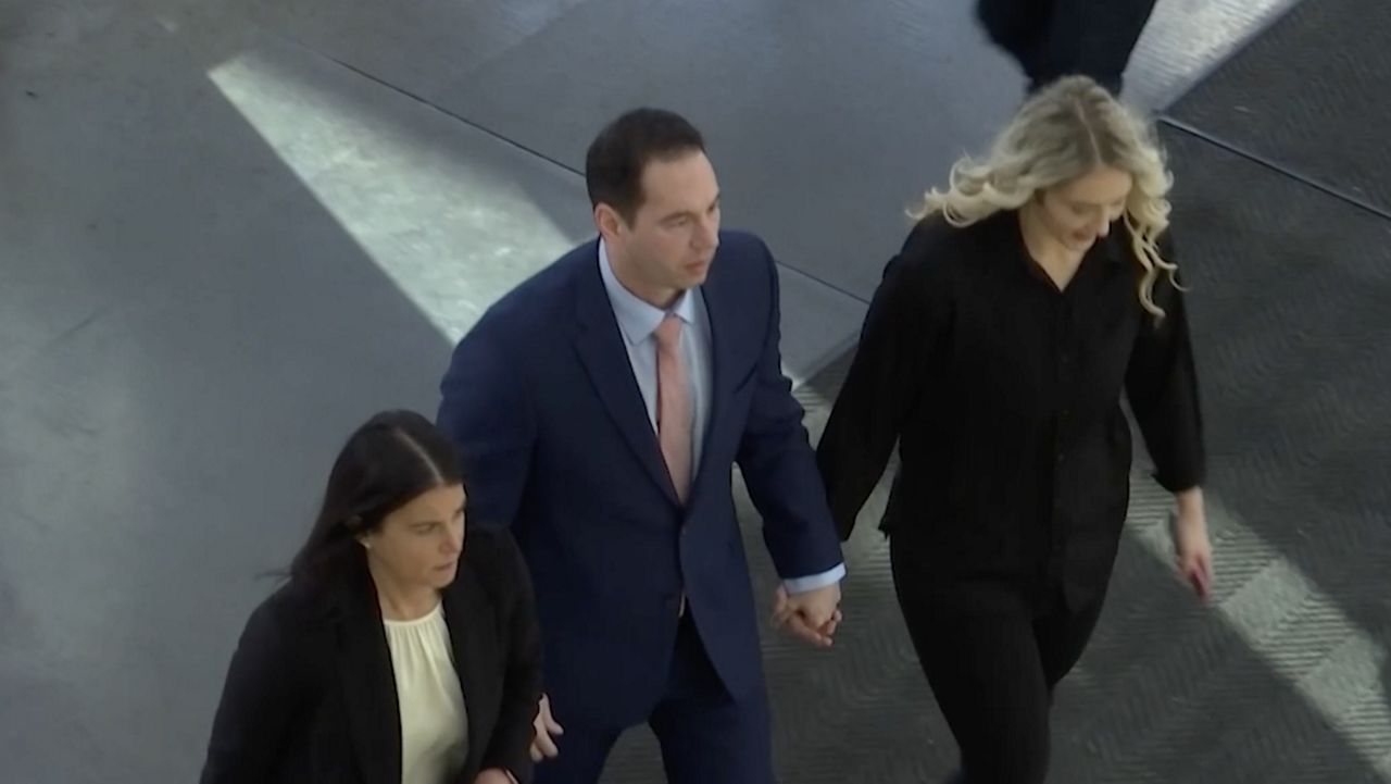Former Mount Carmel doctor, William Husel, walking with his wife and attorney. 