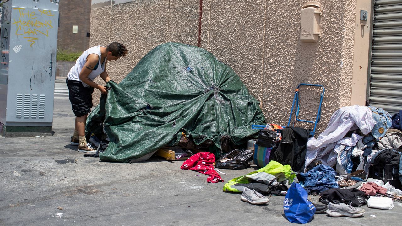 A homeless individual adjusts his tent on Skid Row street in Downtown Los Angeles on Friday, May 31, 2019, five days before Los Angeles officials are set to release the region's official 2019 homeless count on June 4th.(Jeff Lewis/AP Images for AIDS Healthcare Foundation)