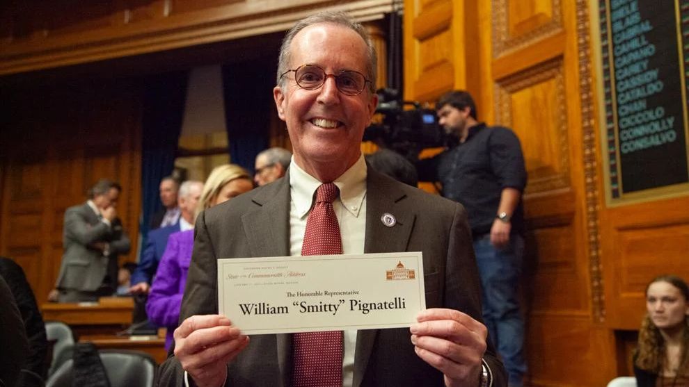 State Rep. William "Smitty" Pignatelli poses with the placard from his desk at the 2024 State of the State speech in the House Chamber. (State House News Service/Sam Doran)