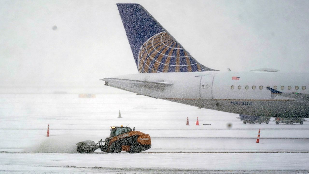 Snow and ice are cleared outside a parked plane at Dallas Fort Worth International Airport in Grapevine, Texas, Thursday, Feb. 3, 2022.