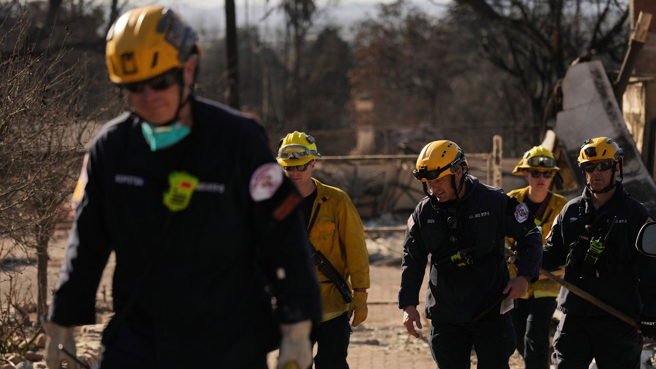 Search and rescue workers dig through the rubble left behind by the Eaton Fire, in Altadena, Calif., Tuesday, Jan. 14, 2025. (AP Photo/Jae C. Hong)