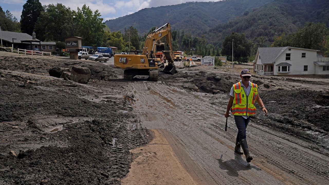 Paul Burgess, with the California Geological Survey, walks along the town's main road in the aftermath of a mudslide Tuesday, Sept. 13, 2022, in Oak Glen, Calif.