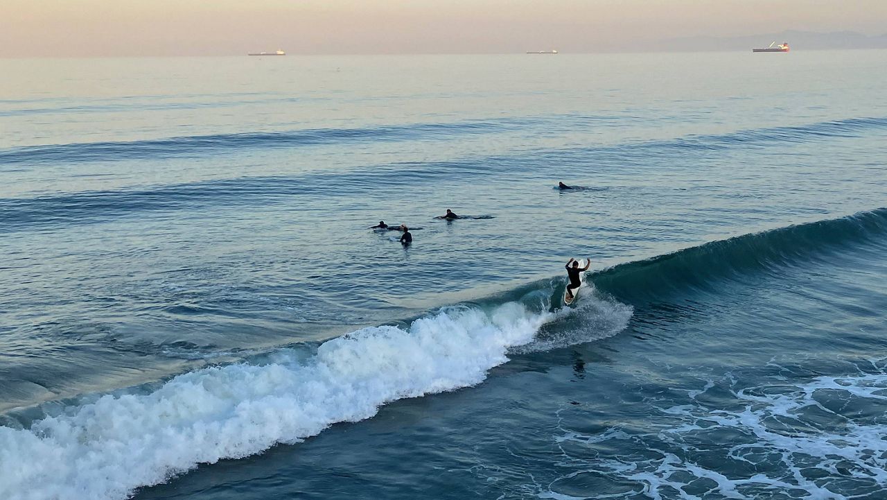 Surfers catch the sunrise swell at Manhattan Beach, Calif., on Monday, Sept. 5, 2022, as a severe heat wave gripped the state. (AP Photo/John Antczak)