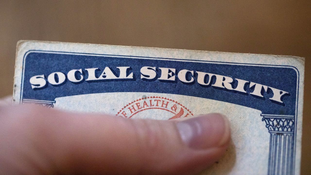 A Social Security card is displayed, number obscured by a finger