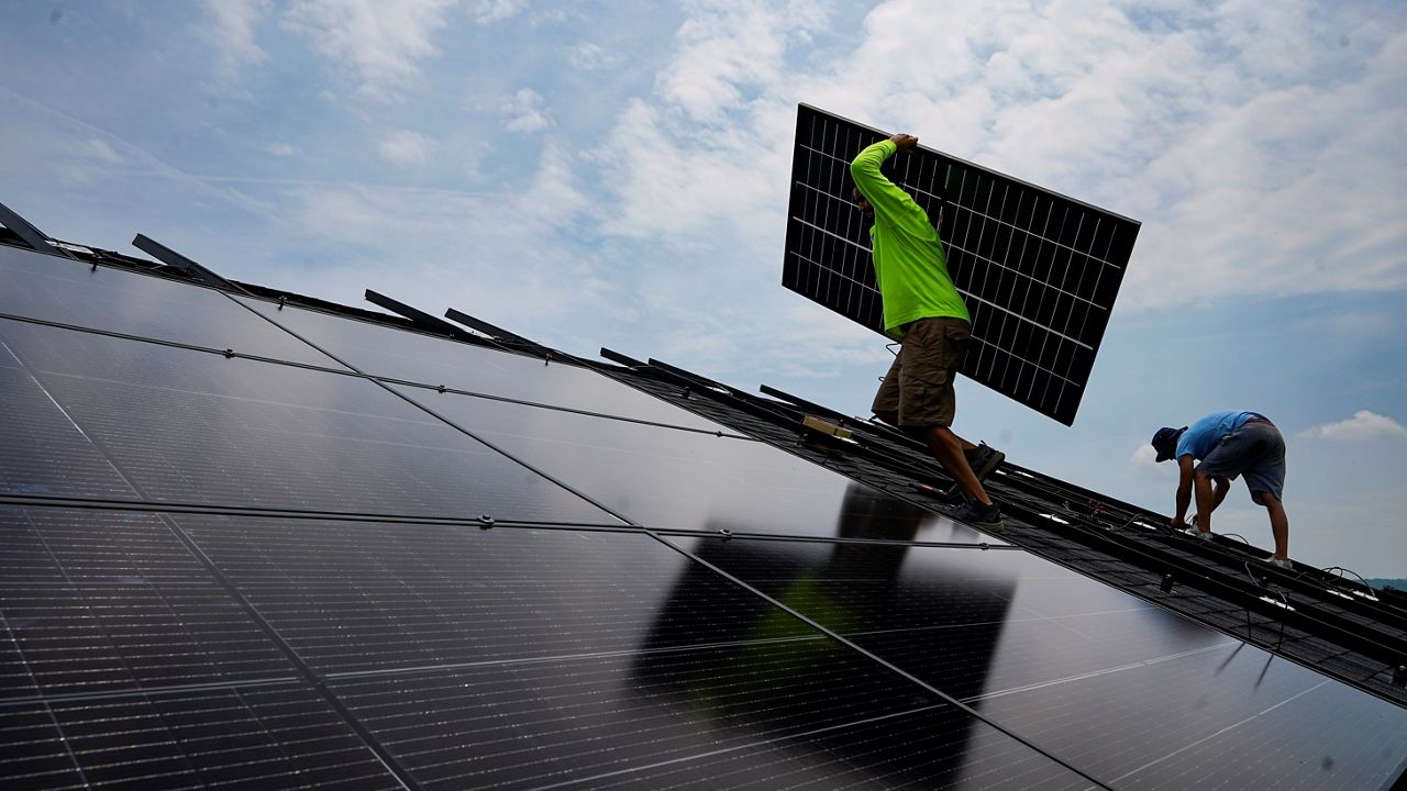 man installing solar panels on a kentucky homeowner's roof during a bright summer day