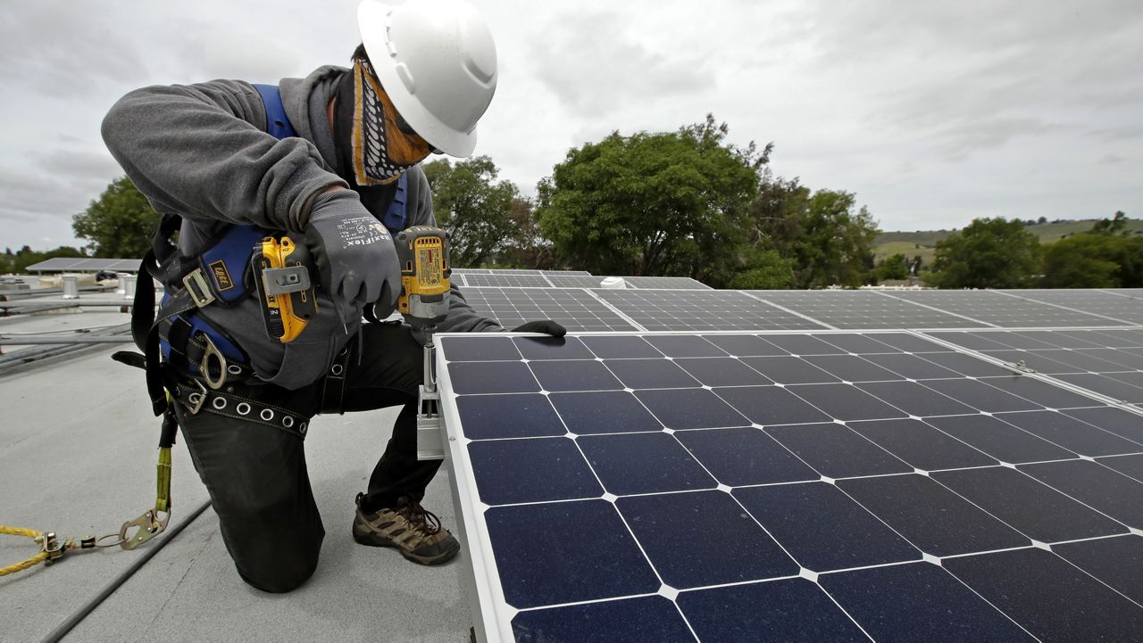 Gen Nashimoto, of Luminalt, installs solar panels in Hayward, Calif., on April 29, 2020. (AP Photo/Ben Margot, File)