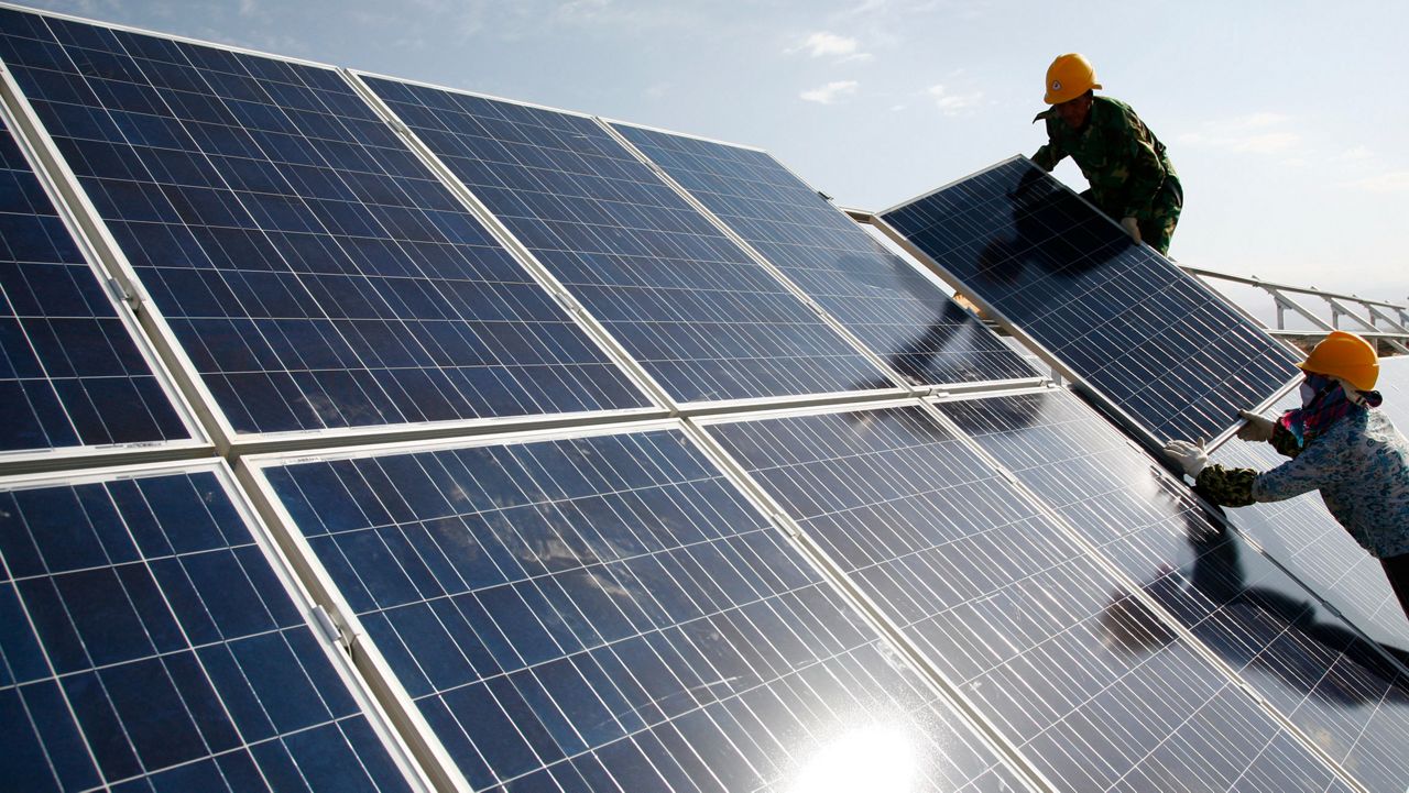 solar panels with the sun shining behind