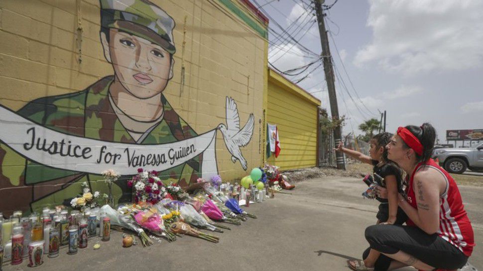 Dawn Gomez holds her 3-year-old granddaughter, Saryia Greer, who waves at Vanessa Guillen's mural painted by Alejandro "Donkeeboy" Roman Jr. on the side of Taqueria Del Sol, Thursday, July 2, 2020, in Houston. Army investigators believe Guillen, a Texas soldier missing since April, was killed by another soldier on the Texas base where they served, the attorney for the missing soldier's family said Thursday. (Steve Gonzales/Houston Chronicle via AP)