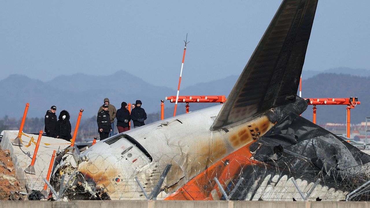 Experts from the U.S. National Transportation Safety Board (NTSB) and joint investigation team between the U.S. and South Korea check the site of a plane crash at Muan International Airport in Muan, South Korea, Tuesday, Dec. 31, 2024. (Son Hyung-joo/Yonhap via AP)