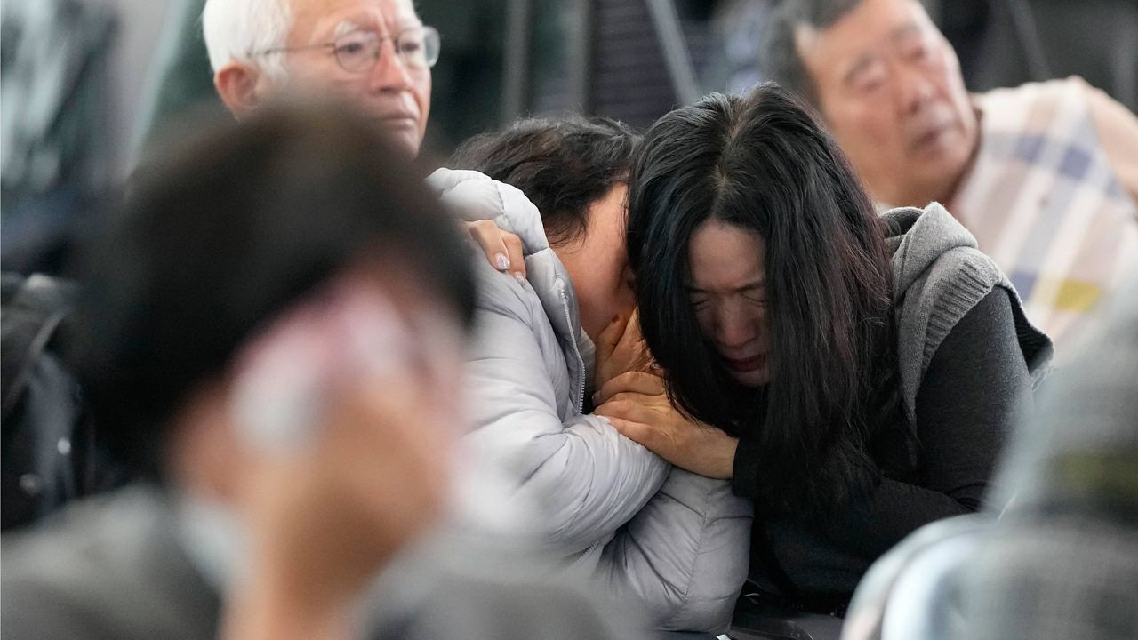 Relatives of passengers on a plane which skidded off a runway and burst into flames, react at Muan International Airport in Muan, South Korea, Monday, Dec. 30, 2024. (AP Photo/Ahn Young-joon)