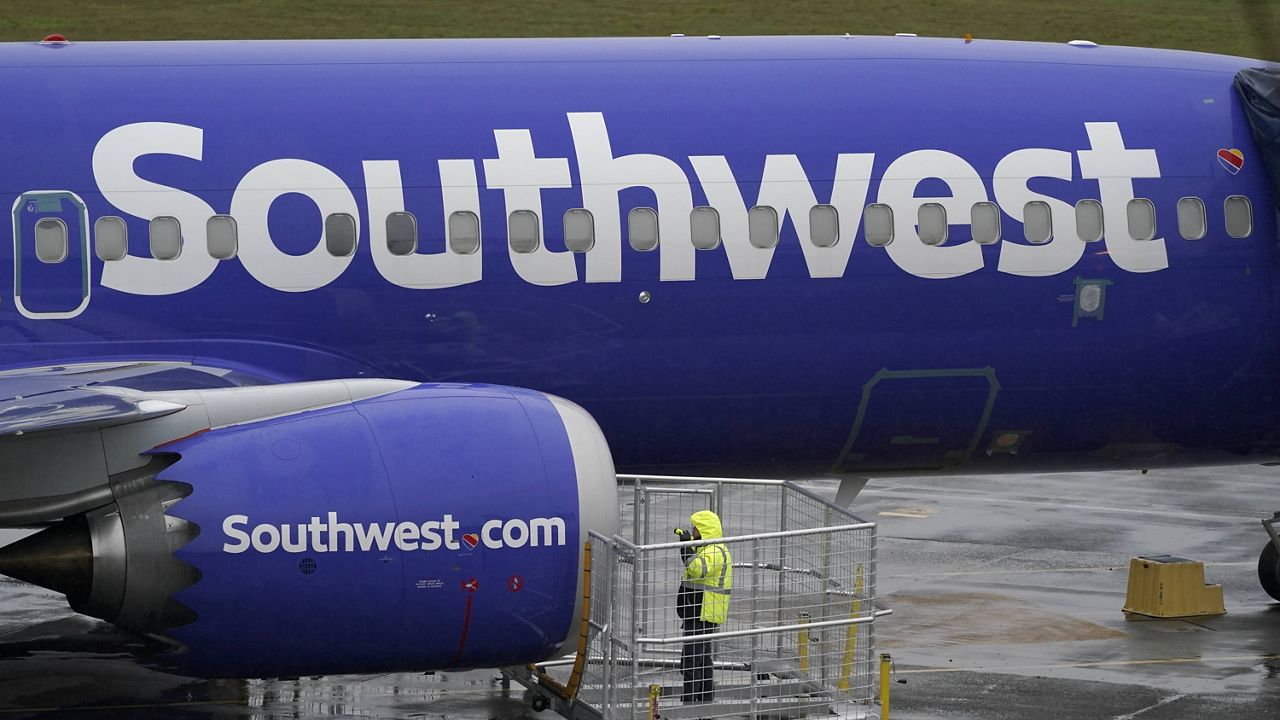 a worker uses a flashlight to inspect an engine on a Boeing 737 Max 8 built for Southwest Airlines at Renton Municipal Airport in Renton, Wash. (AP Photo/Ted S. Warren, File)