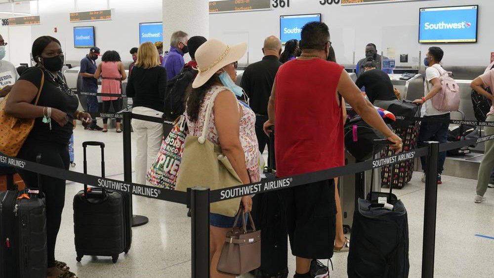 Southwest passengers wait to check in at Miami International Airport, Tuesday, Oct. 12, 2021, in Miami. Southwest Airlines appears to be fixing problems that caused the cancellation of nearly 2,400 flights over the previous three days. By midday Tuesday, Southwest had canceled fewer than 100 flights, although more than 400 others were running late. (AP Photo/Marta Lavandier)