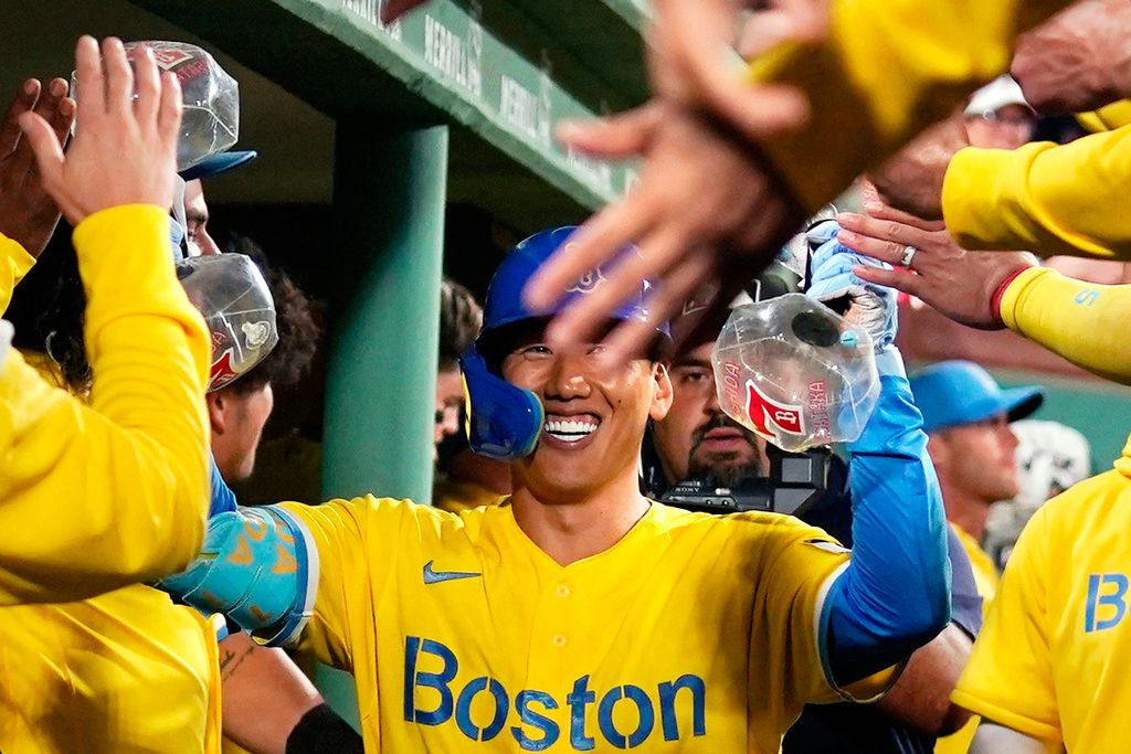 Adam Duvall of the Boston Red Sox is congratulated in the dugout