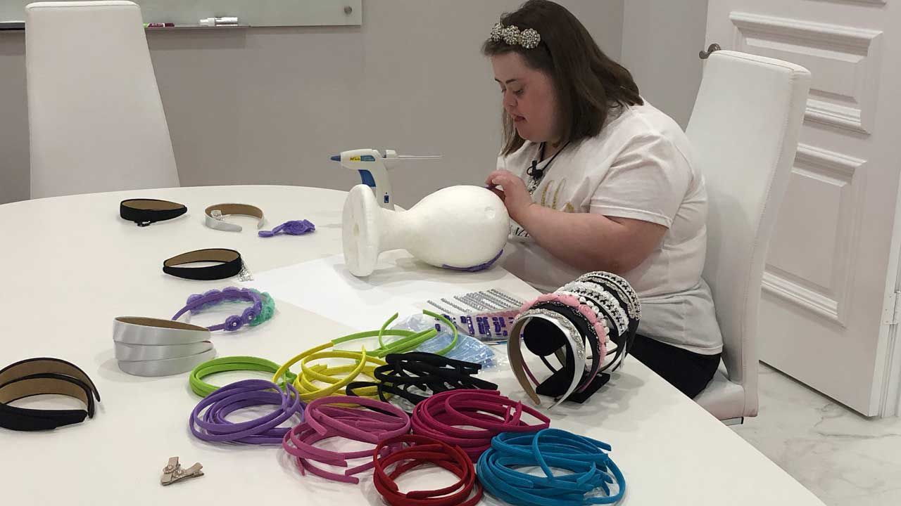 Maxine Simeone, 23, works on crafting one of her signature headbands. Maxine has Down syndrome, but it hasn't stopped her from expressing her creativity and starting a business called "Sparkles by Maxine." (Ashley Paul/Spectrum Bay News 9)