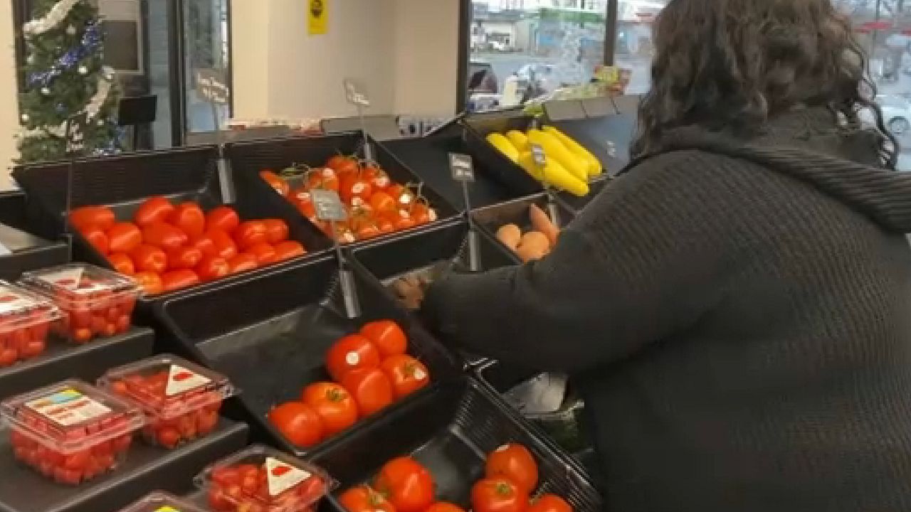 woman setting up fruit in store