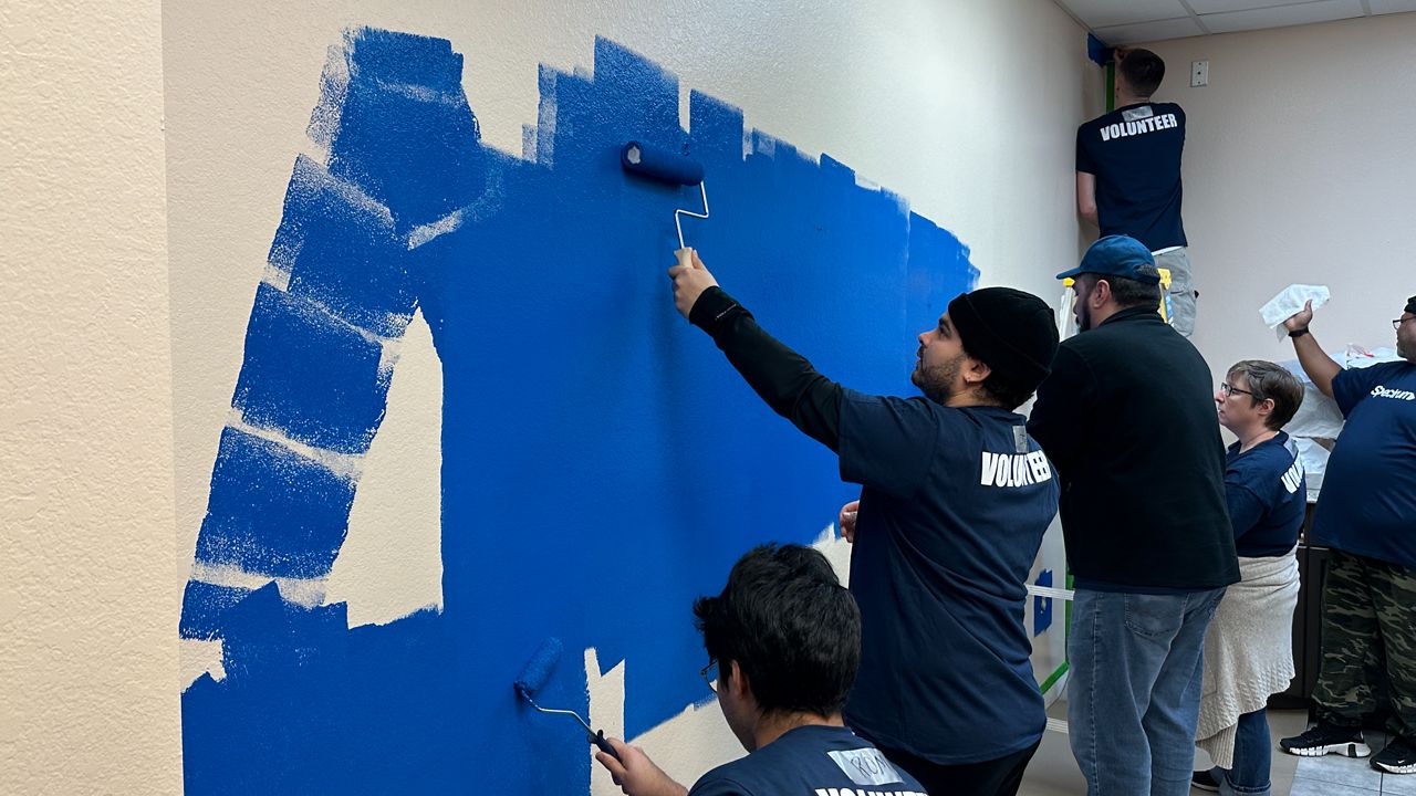 Volunteers paint the office of a CareerSource location. (Spectrum News/Philip Peterson)