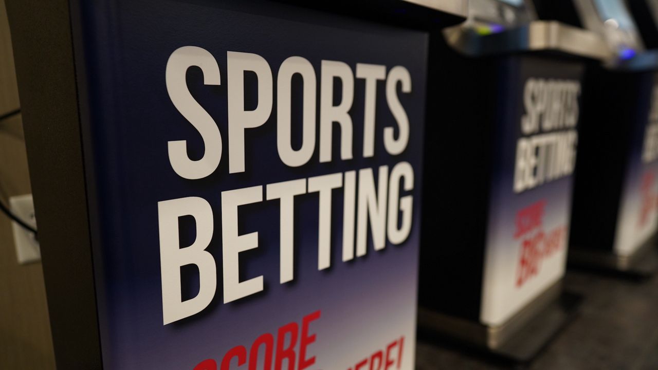A photo of a kiosk that has white "sports betting" text on it.