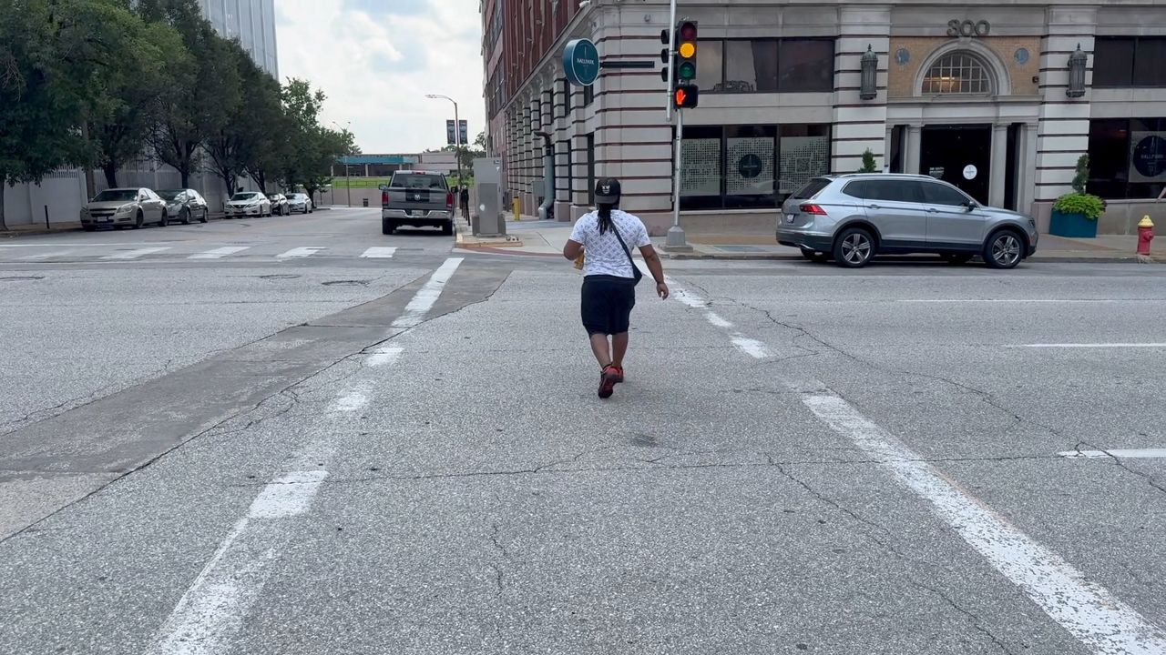 A Man walks across the street in a crosswalk of downtown St. Louis.