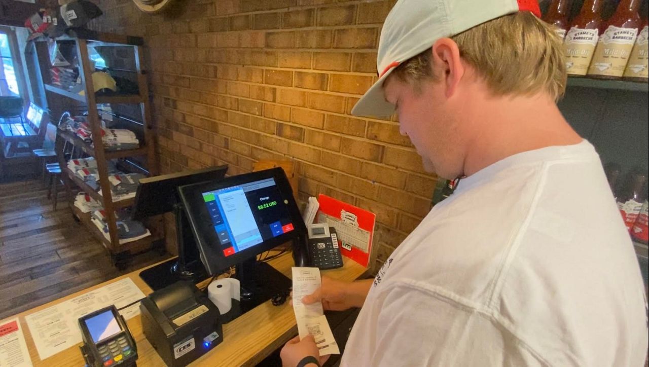 Craver Stamey checkinCraver Stamey checks out a customer at Stamey's Barbecue. (Spectrum News 1/Zyneria Byrd)g someone out at register at Stamey's Barbecue. (Spectrum News 1/Zyneria Byrd)