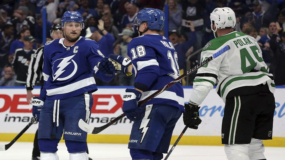Tampa Bay Lightning's Steven Stamkos, left, celebrates his goal with Ondrej Palat, of the Czech Republic, as Dallas Stars' Roman Polak, of the Czech Republic, skates past during the second period of an NHL hockey game Thursday, Feb. 14, 2019, in Tampa, Fla. (AP Photo/Mike Carlson)