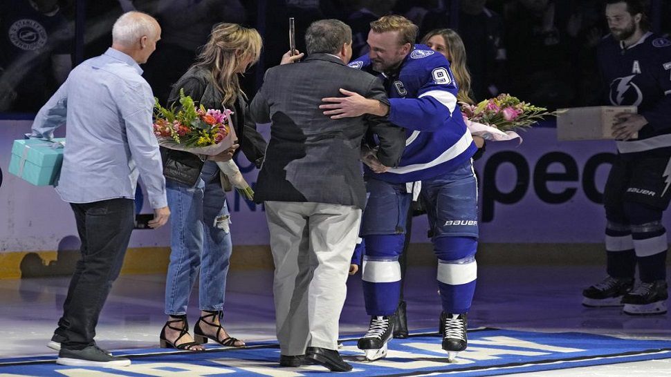 Tampa Bay Lightning center Steven Stamkos (91) hugs team owner Jeff Vinik after being presented with a gold hockey stick before an NHL hockey game against the Toronto Maple Leafs Saturday, Dec. 3, 2022, in Tampa, Fla. Stamkos recorded his 1,000th career point earlier in the week. (AP Photo/Chris O'Meara)