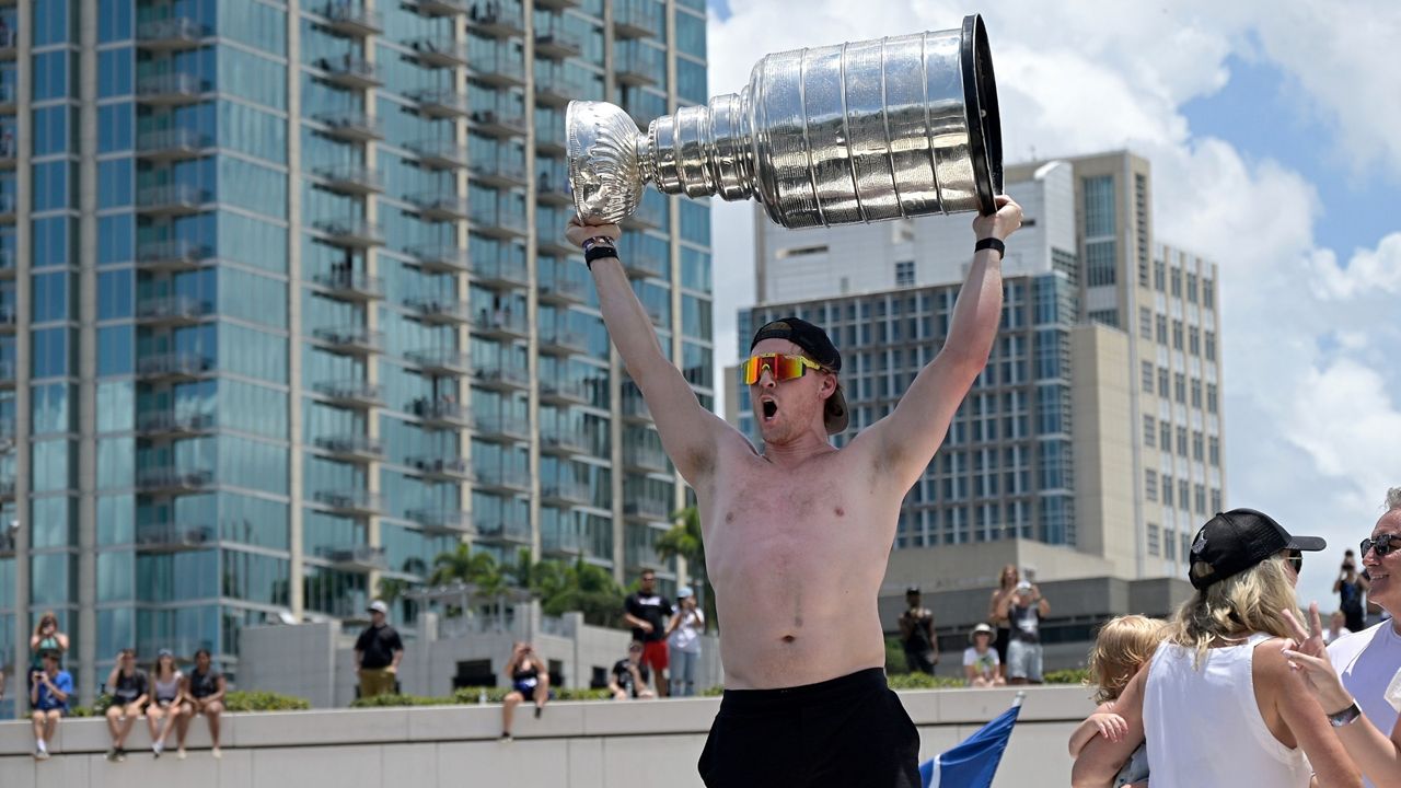 Tampa Bay Lightning center Blake Coleman hoists the Stanley Cup during the NHL hockey Stanley Cup champions' Boat Parade, Monday, July 12, 2021, in Tampa, Fla. (AP/Phelan M. Ebenhack)