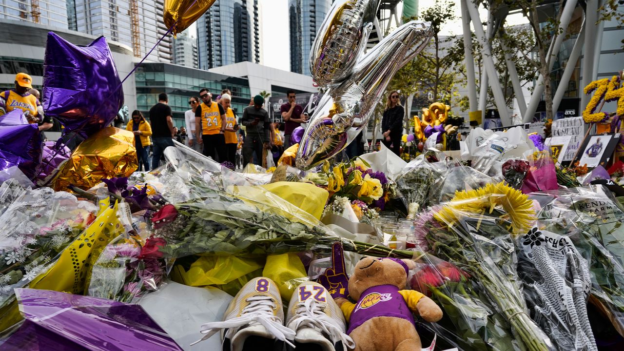 Sneakers with NBA star Kobe Bryant's numbers on them are left at a memorial for Bryant while fans gather to pay their respects near Staples Center in downtown Los Angeles on Jan. 30, 2020. (AP Photo/Richard Vogel)
