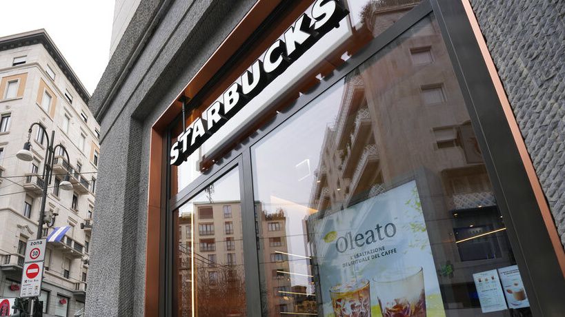 Pedestrians pass a Starbucks in New York on June 13. (AP Photo/John Minchillo)