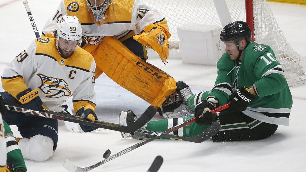 Nashville Predators defenseman Roman Josi (59) and Dallas Stars right wing Corey Perry (10) battle for the puck as Predators goaltender Juuse Saros (74) looks on during the second period of an NHL hockey game Saturday, March 7, 2020, in Dallas. (AP Photo/Ron Jenkins)