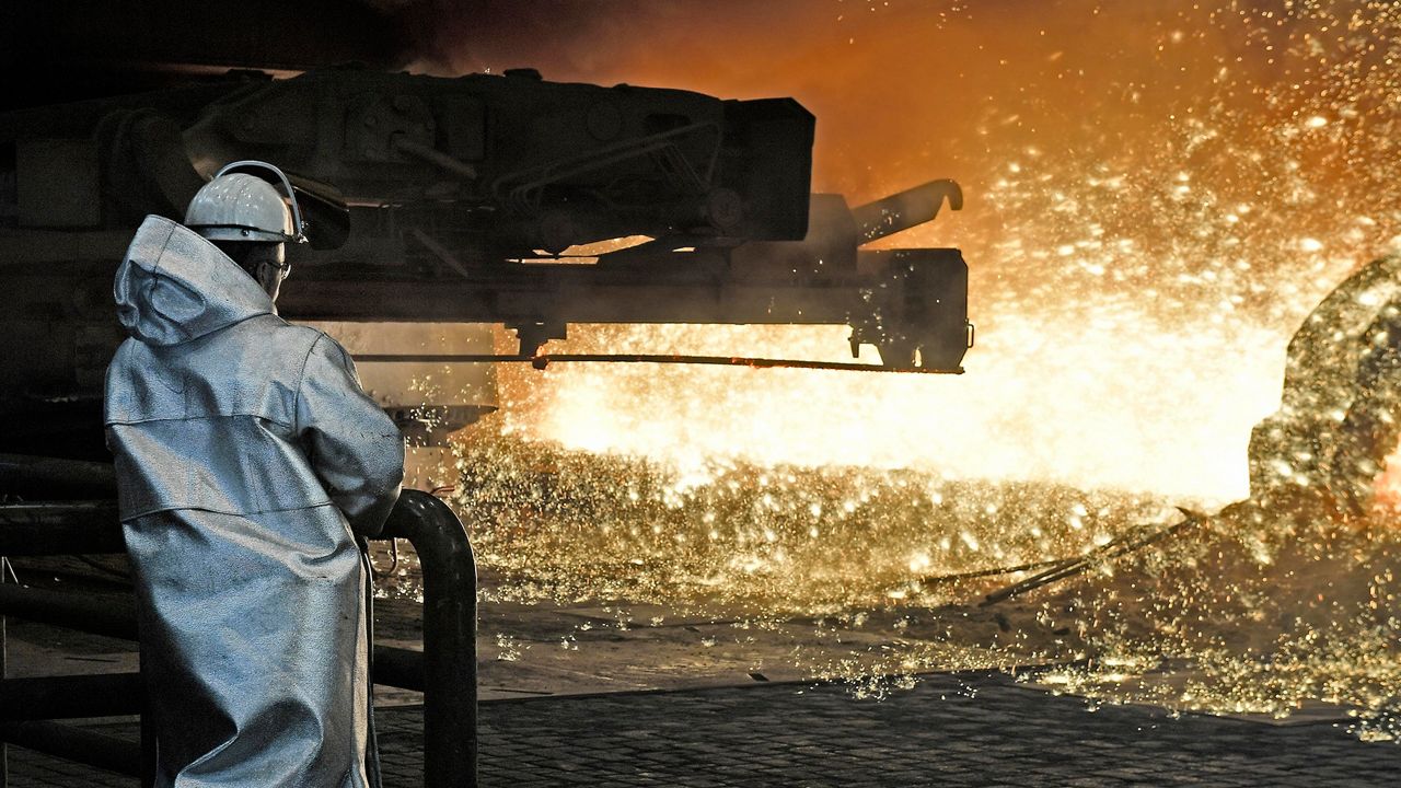 A steel worker watches hot metal in a factory. (AP Photo/Martin Meissner)