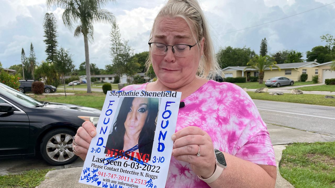 Jennifer Massrock holds up a missing persons photo of Stephanie Shenefield, 38, who was found dead in Palmetto Thursday. (Spectrum Bay News 9/Sarah Blazonis)