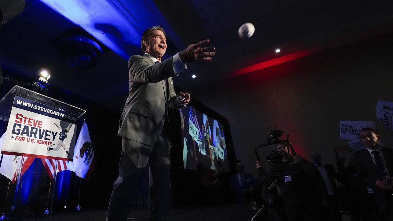 Republican U.S. Senate candidate Steve Garvey tosses a baseball to supporters during his election night party, Tuesday, March 5, 2024, in Palm Desert, Calif. (AP Photo/Gregory Bull)