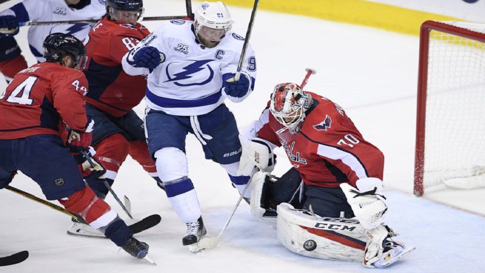 Washington Capitals goaltender Braden Holtby (70) stops the puck next to Tampa Bay Lightning center Steven Stamkos (91) during the second period of Game 4 of the NHL hockey Eastern Conference finals Thursday, May 17, 2018, in Washington. Also seen is Capitals defenseman Brooks Orpik (44). (AP Photo/Nick Wass)