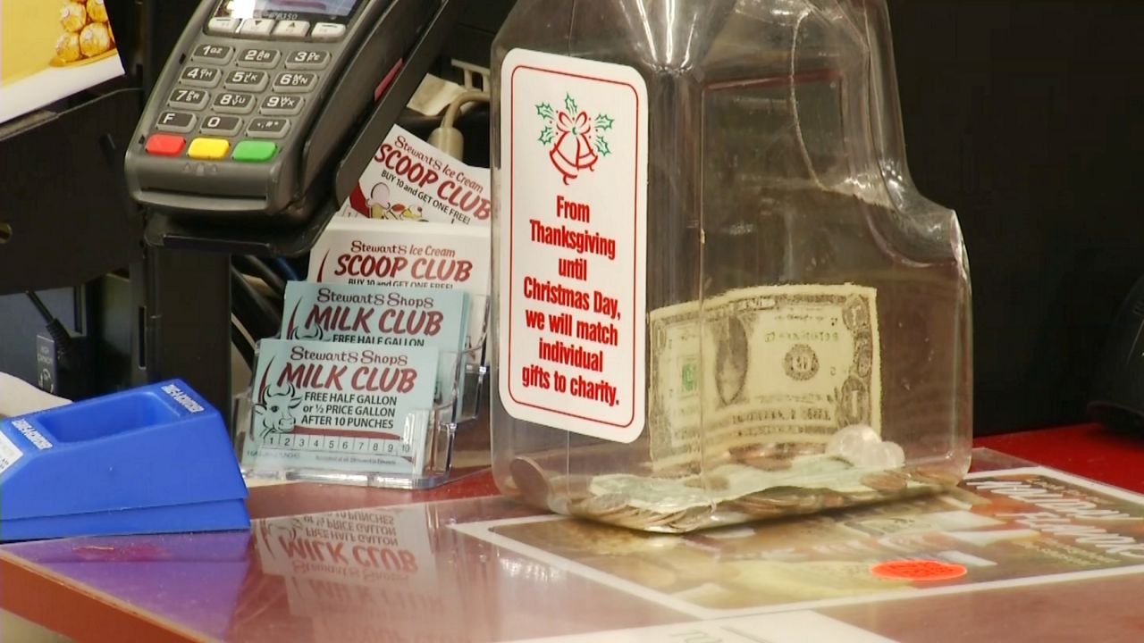 stewart's holiday match jar, with a couple of dollar bills in it, on a stewart's checkout counter