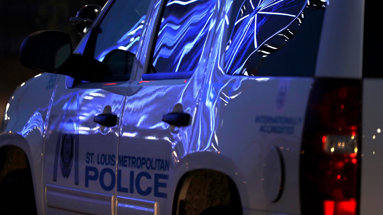 A ferris wheel illuminated by blue lights is reflected on the side of a police car outside Union Station, Thursday, April 9, 2020, in St. Louis. (AP/Jeff Roberson)