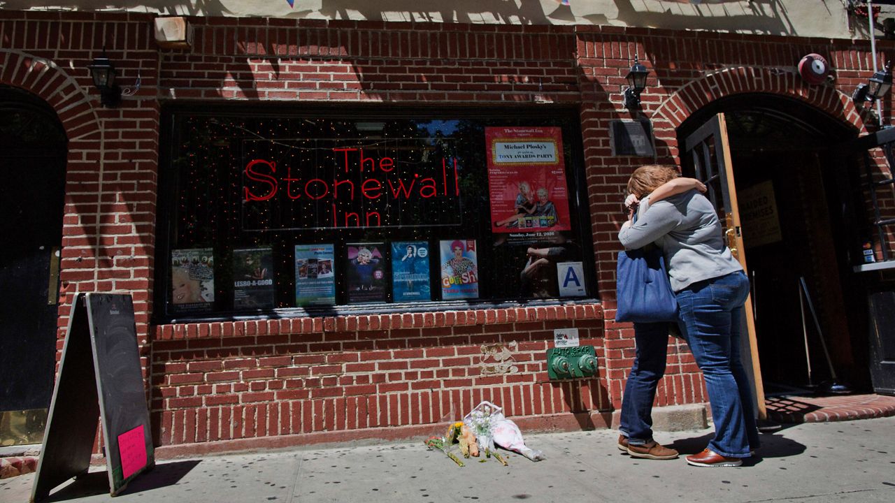 In this June 12, 2016 file photo, a couple embraces outside the Stonewall Inn in New York. (AP Photo/Mary Altaffer)