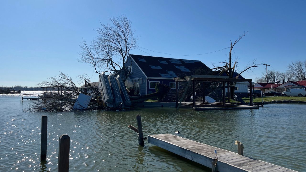 A boat sits upside down on a tree on Orchard Island in Russells Point, Ohio, on Saturday, March 16, 2024. 