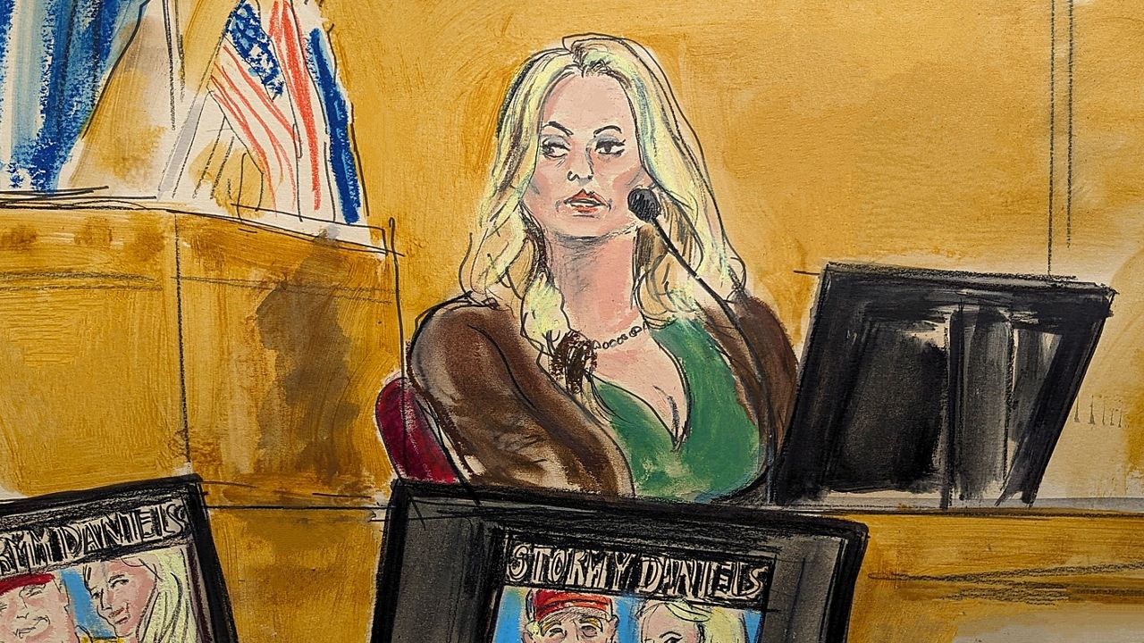 Stormy Daniels testifies on the witness stand as a promotional image for one of her shows featuring an image of Trump is displayed on monitors in Manhattan criminal court, Thursday, May 9, 2024, in New York. (Elizabeth Williams via AP)