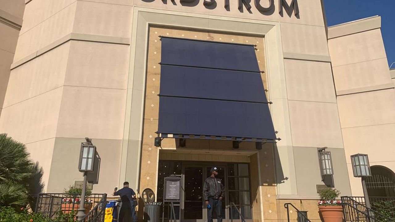 A security guard stands outside the Nordstrom store at The Grove retail and entertainment complex in Los Angeles, on Nov. 23, 2021. (AP Photo/Eugene Garcia, File)