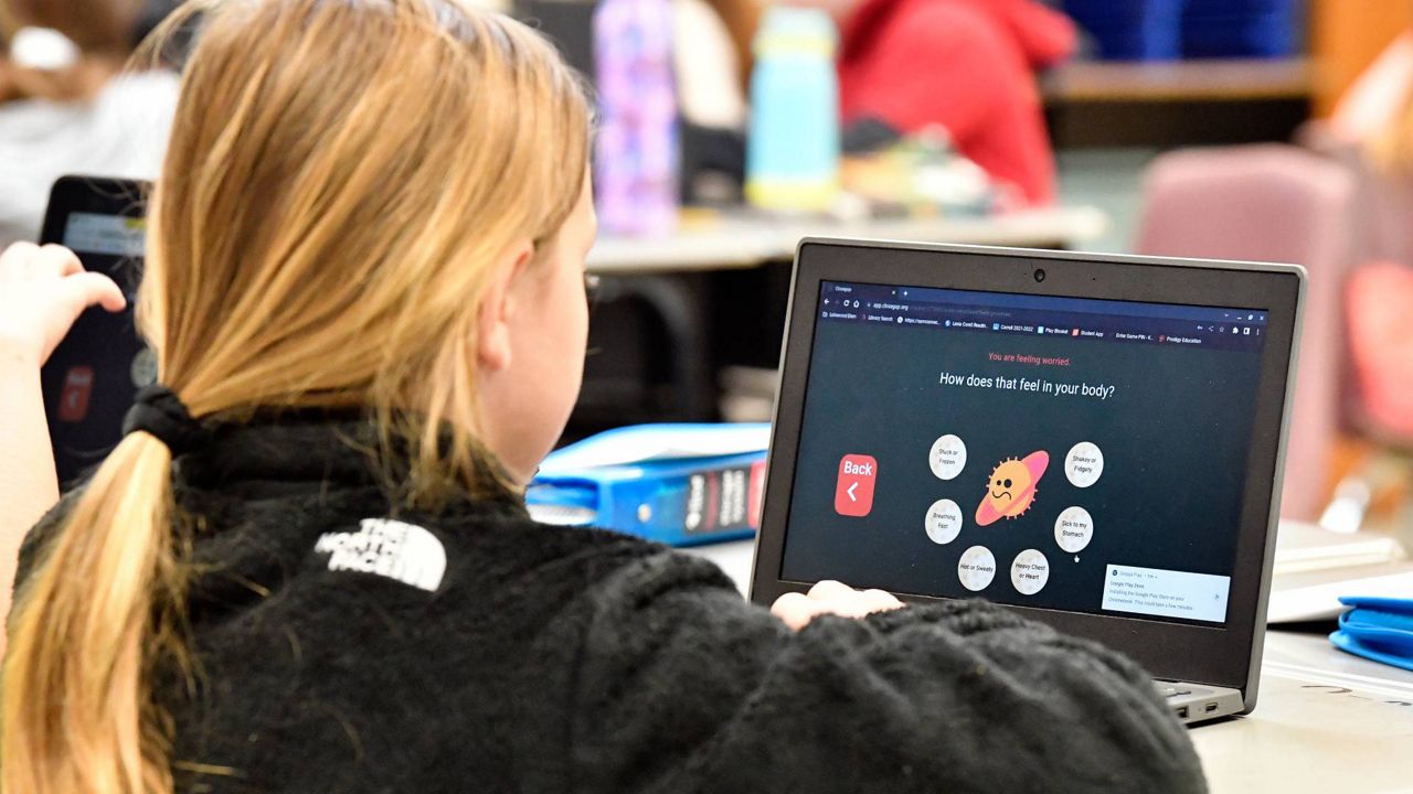A student at Lakewood Elementary School in Cecilia, Ky., uses her laptop to participate in an emotional check-in at the start of the school day, Thursday, Aug. 11, 2022. (AP Photo/Timothy D. Easley)