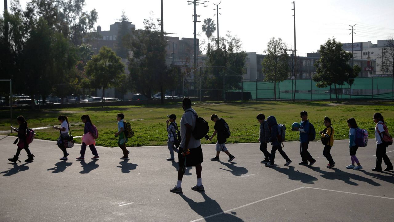 A group of students walk back to their classroom after finishing their afternoon snack at Kingsley Elementary School, Jan. 13, 2015, in Los Angeles. (AP Photo/Jae C. Hong)