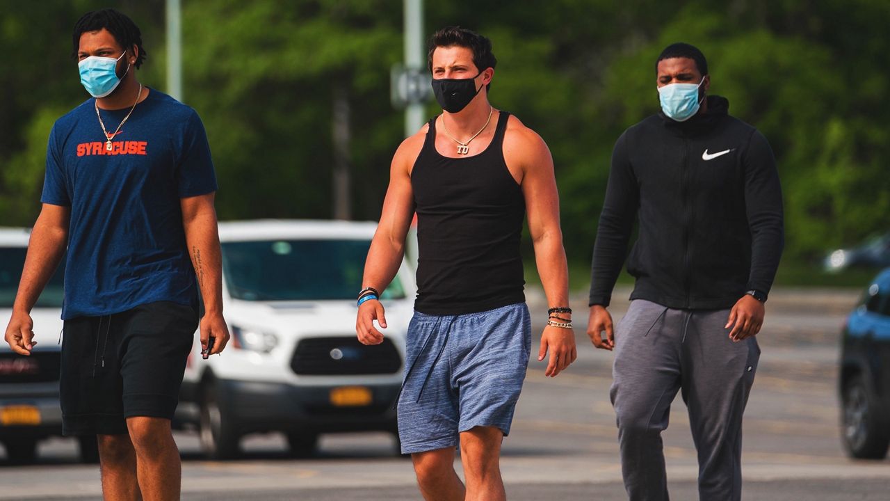 Junior QB Tommy DeVito and two teammates are seen wearing protective masks after returning to the SU campus to begin preparing for training camp.