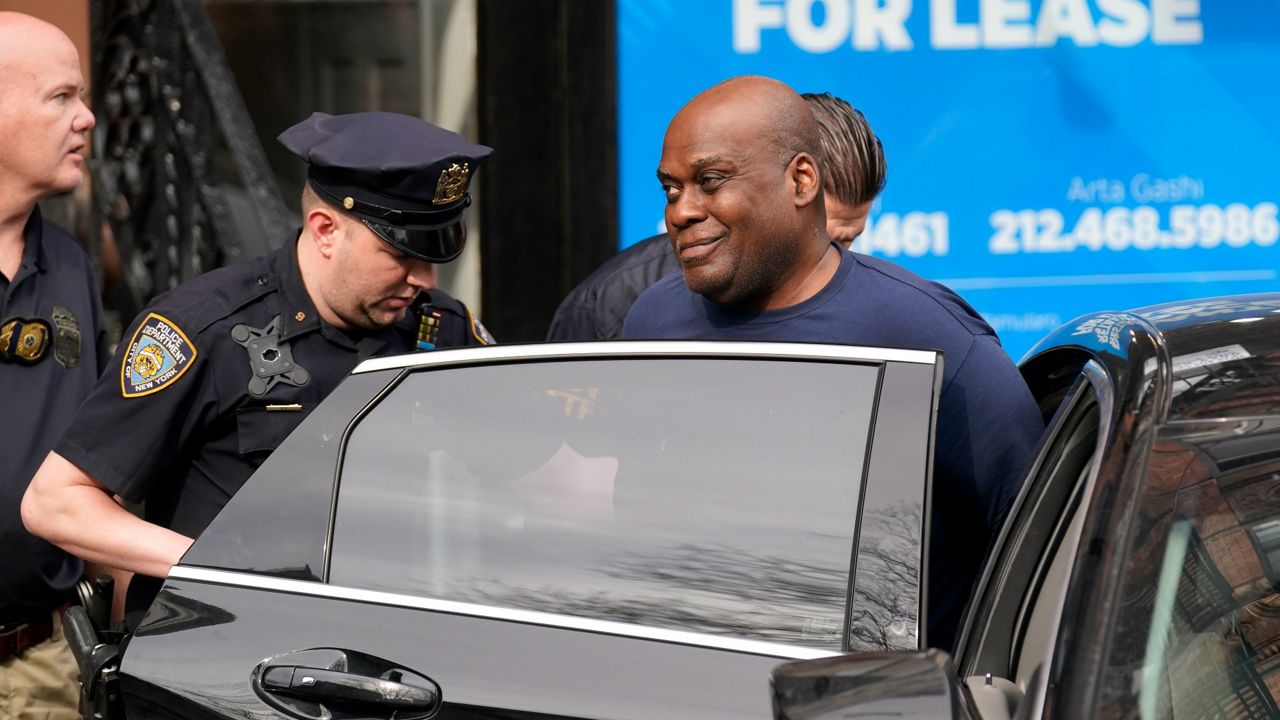 New York City Police and law enforcement officials lead subway shooting suspect Frank R. James, 62, front right, into a car and away from a police station in New York, Wednesday, April 13, 2022. (AP Photo/Seth Wenig)