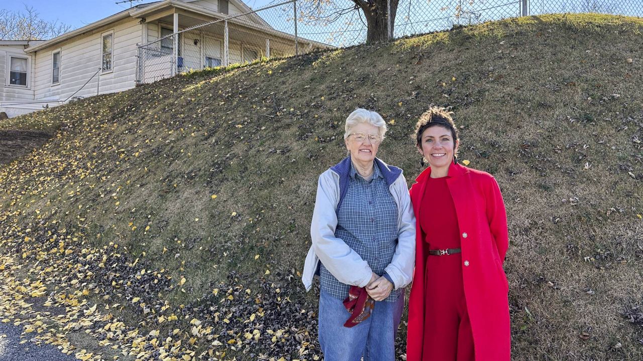 Joan Heckenberg and St. Louis Alderman Cara Spencer stand in front of Heckenberg's home, which sits atop the last remaining Native American mound in St. Louis, on Wednesday, Nov. 20, 2024. (AP Photo/Jim Salter)