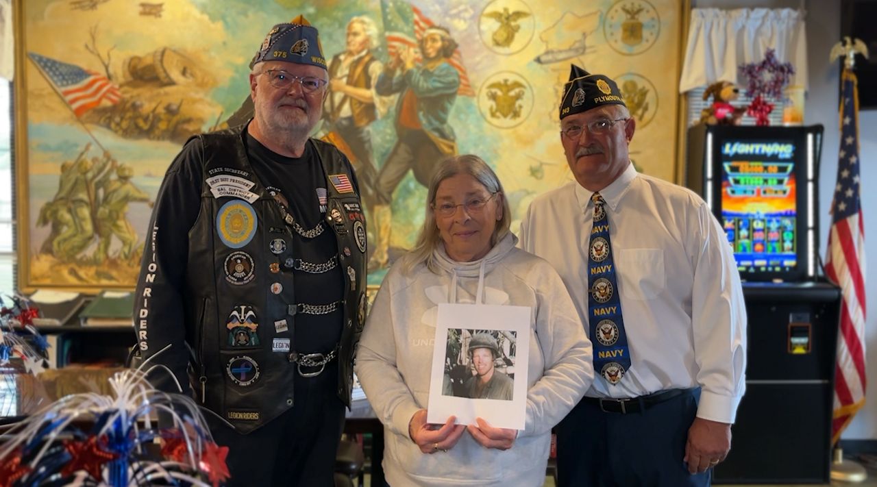 Randy Timms, Sue Ward, and Steven Conto pose with a picture of fallen soldier, Terrence Sund.