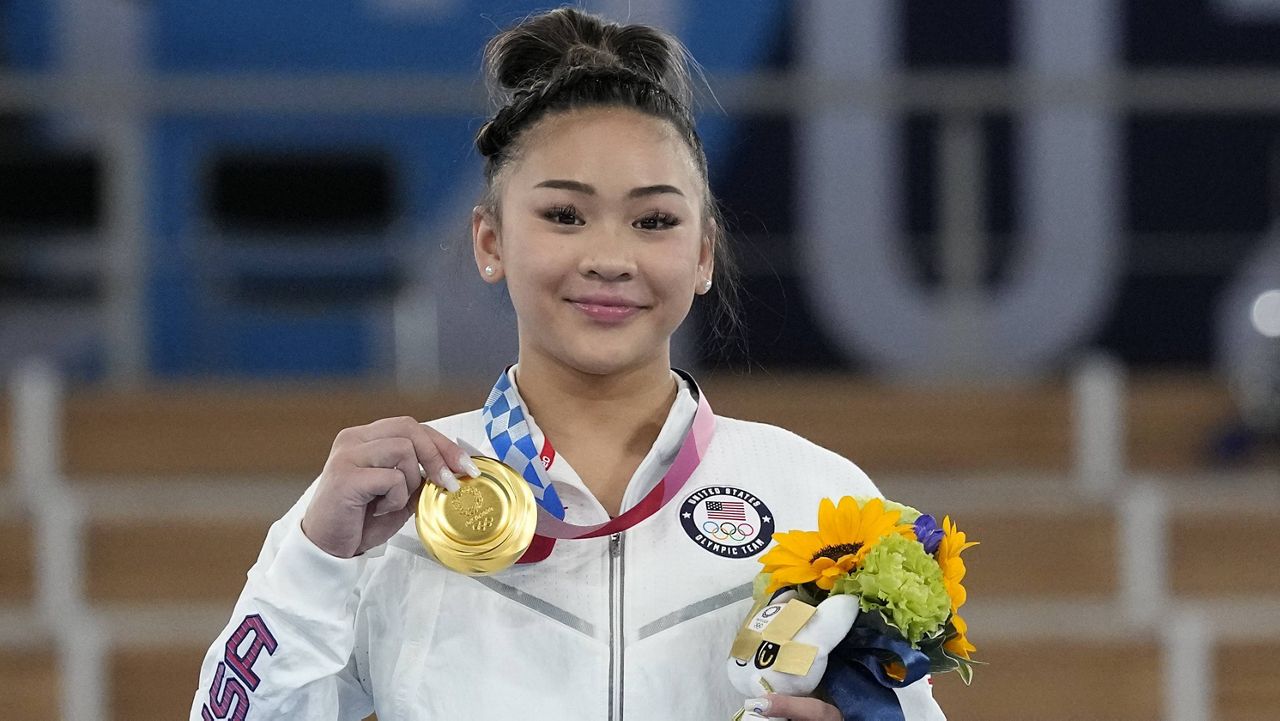 Sunisa Lee displays her gold medal for the artistic gymnastics women's all-around Thursday at the Olympics in Tokyo. (AP Photo/Gregory Bull)