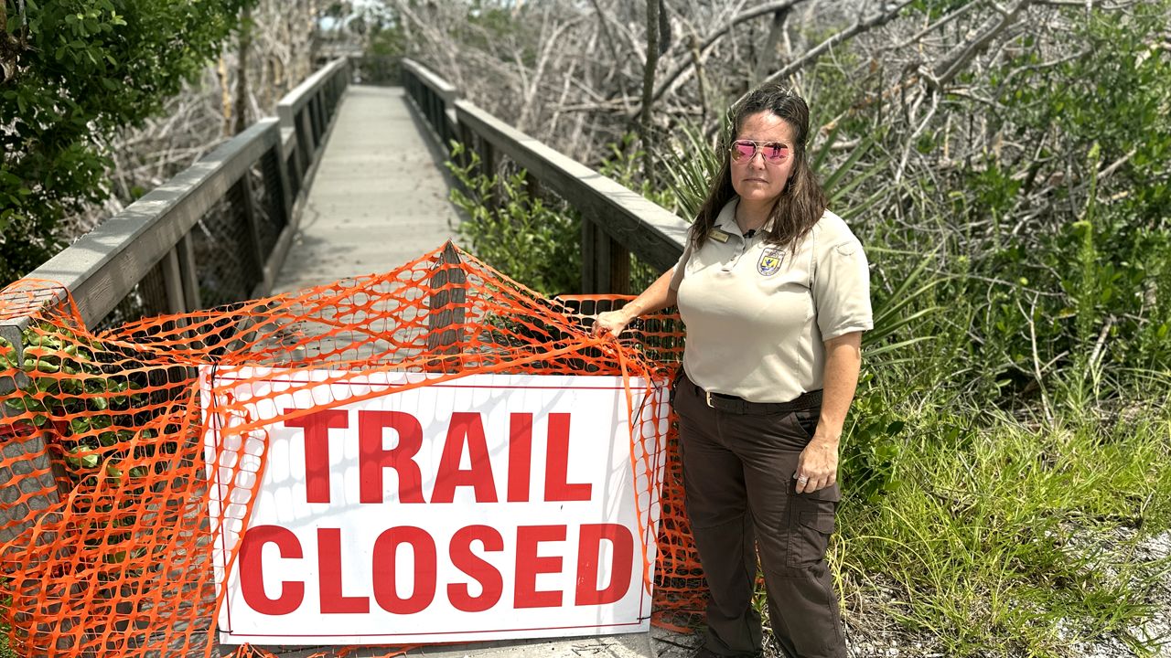 Supervisory Ranger Toni Westland stands beside a closed trail at the J.N. “Ding” Darling Wildlife Refuge.