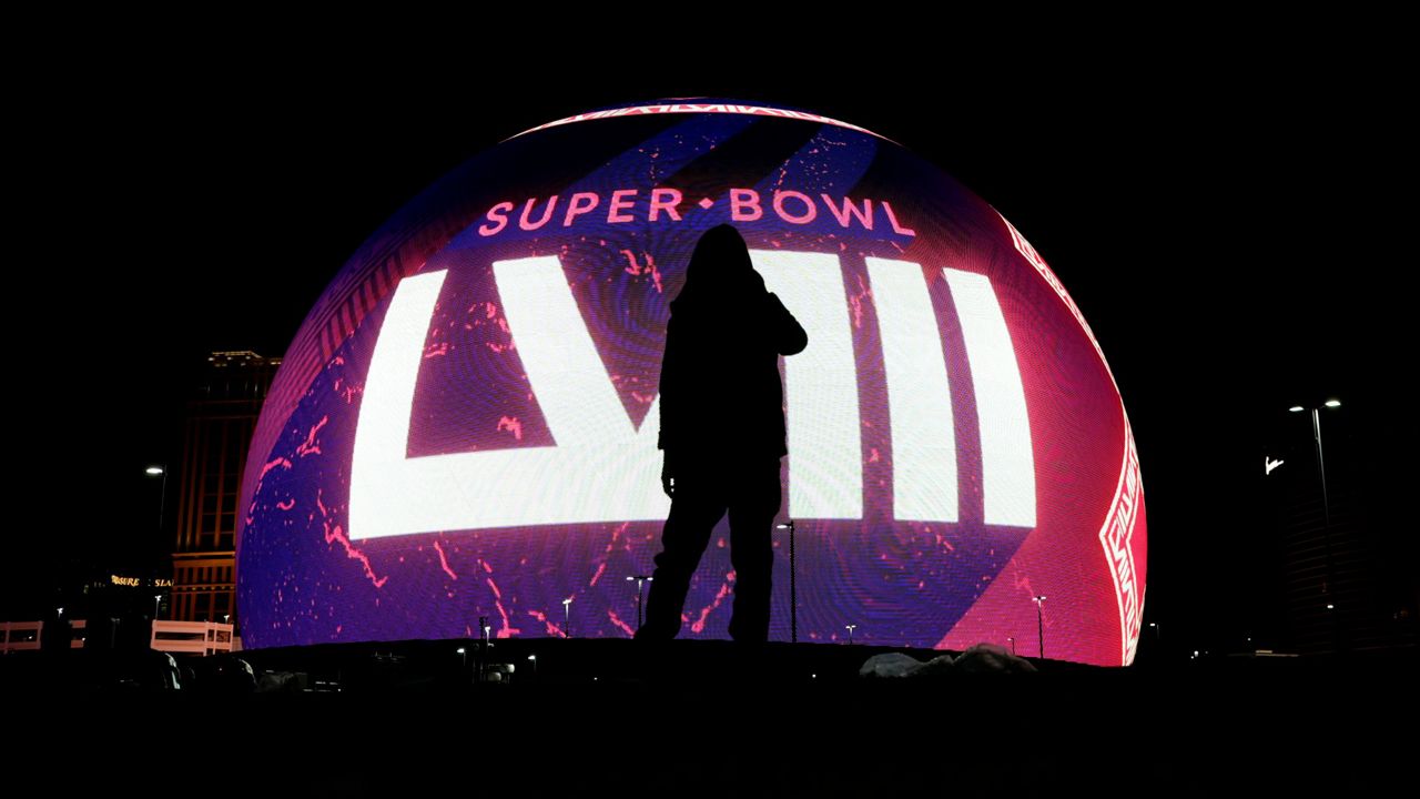 A person is silhouetted against a Super Bowl 58 graphic playing on the Sphere Thursday, Feb. 8, 2024 in Las Vegas. The Kansas City Chiefs will play the NFL football game against the San Francisco 49ers Sunday in Las Vegas. (AP Photo/Charlie Riedel)