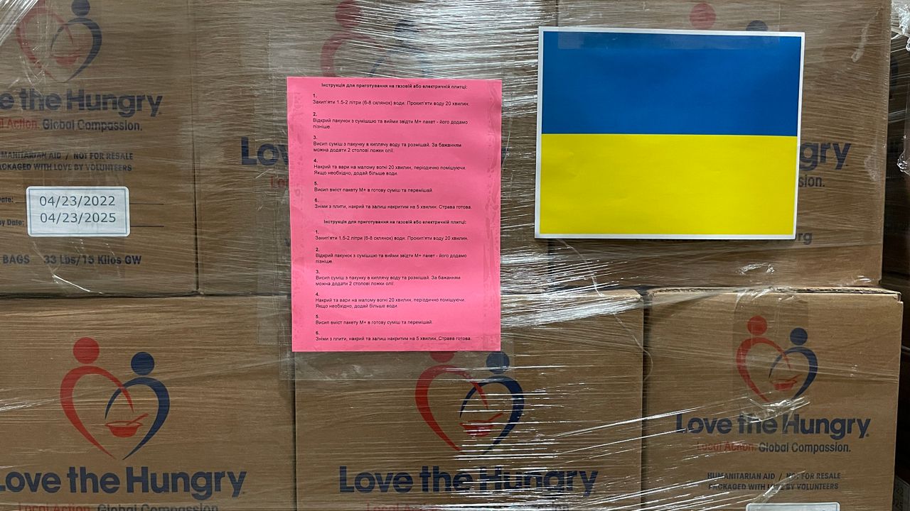 Preparation instructions written in Ukrainian are attached to a pallet of food waiting to be shipped out (Spectrum News 1/Mason Brighton)